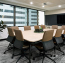 Mila PU chair in Mahogany at a meeting table